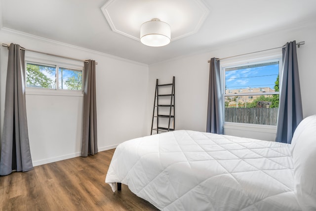 bedroom with dark wood-type flooring, ornamental molding, and multiple windows