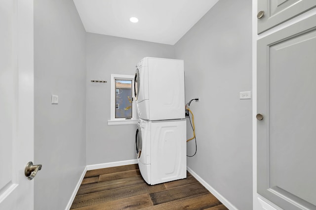 laundry area with stacked washer and clothes dryer and dark hardwood / wood-style flooring