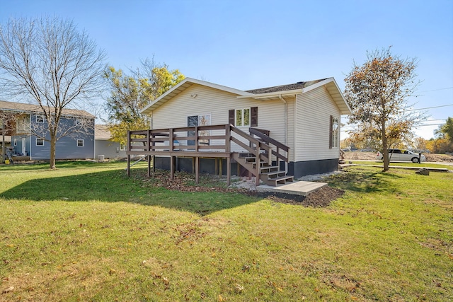 rear view of house with a deck and a lawn