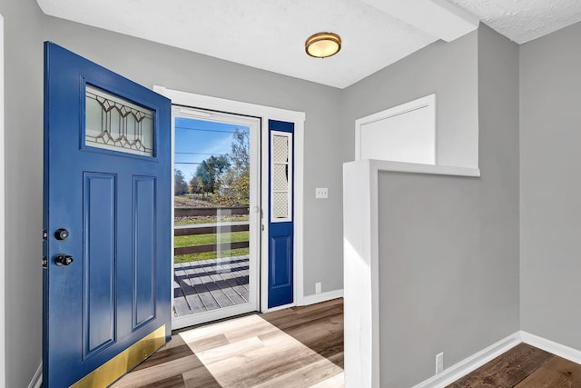 foyer entrance with a textured ceiling and hardwood / wood-style flooring