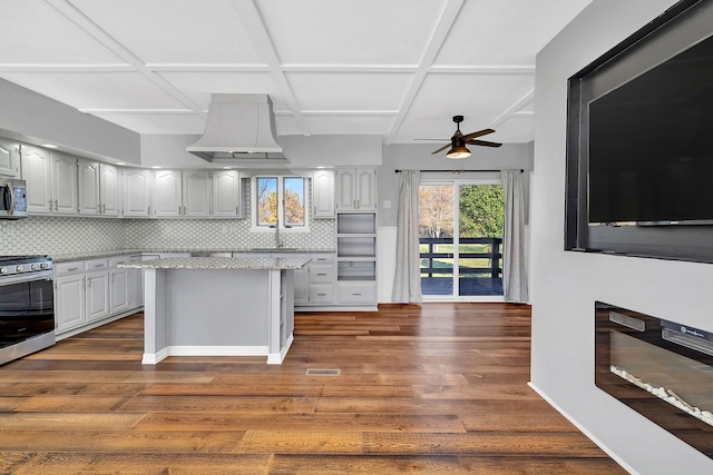 kitchen featuring backsplash, stainless steel appliances, a center island, and dark hardwood / wood-style floors