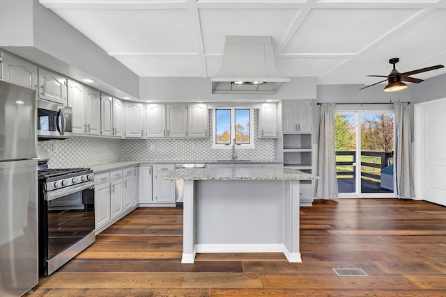 kitchen featuring a center island, appliances with stainless steel finishes, dark hardwood / wood-style floors, and backsplash