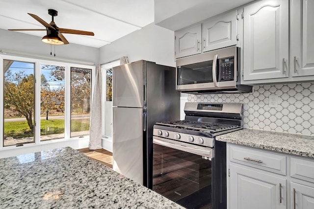 kitchen with appliances with stainless steel finishes, white cabinetry, and light wood-type flooring