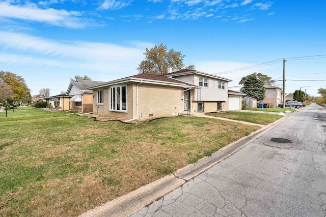 view of side of home featuring a lawn and a garage