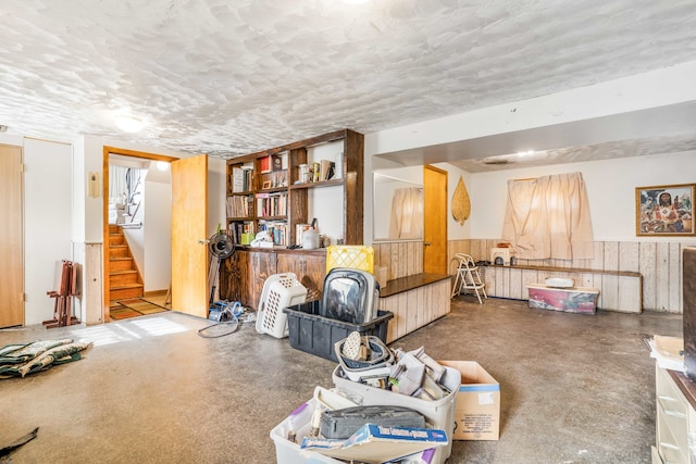 misc room with a textured ceiling and wooden walls