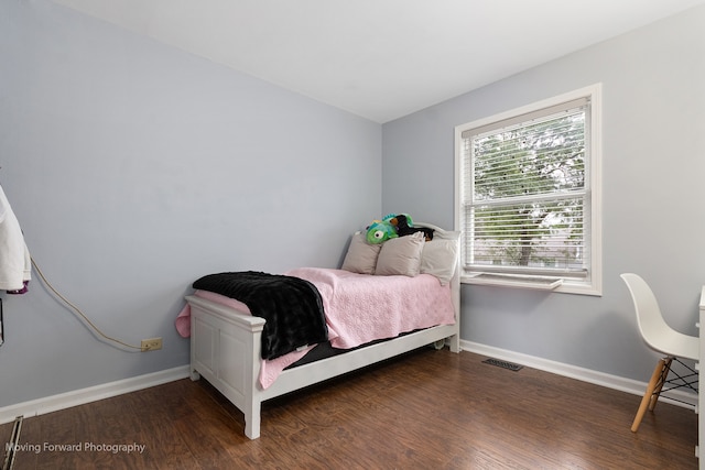 bedroom with dark hardwood / wood-style floors