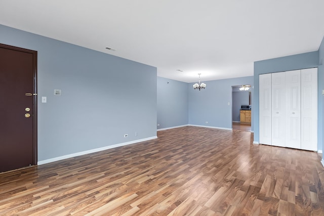 unfurnished living room with hardwood / wood-style flooring and a chandelier