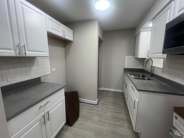 kitchen featuring backsplash, sink, and white cabinets