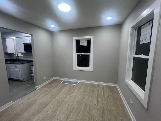 spare room with sink and light wood-type flooring