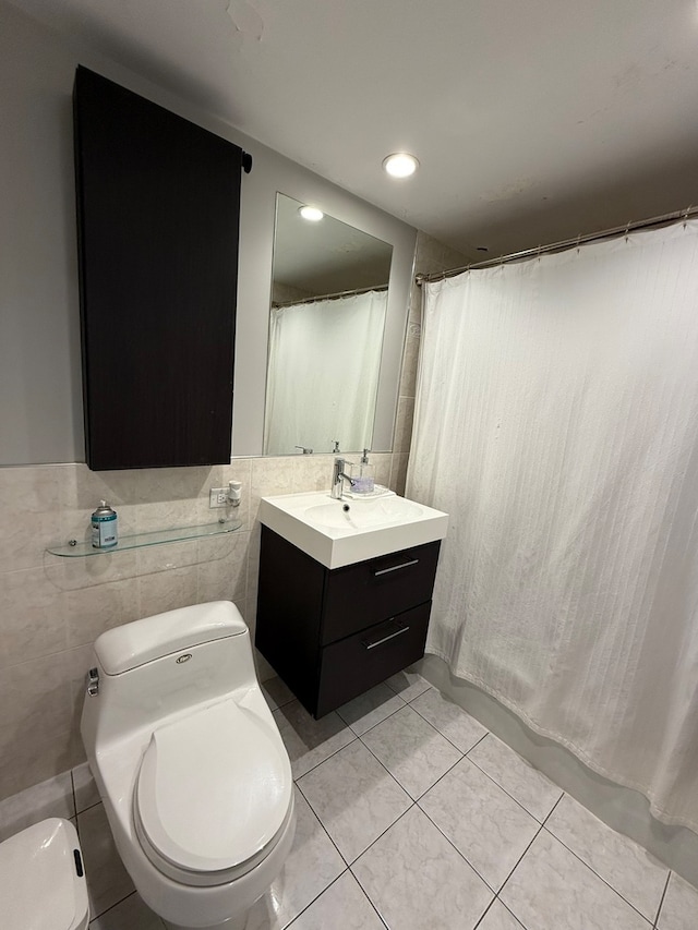 bathroom with toilet, tile walls, walk in shower, vanity, and tile patterned flooring