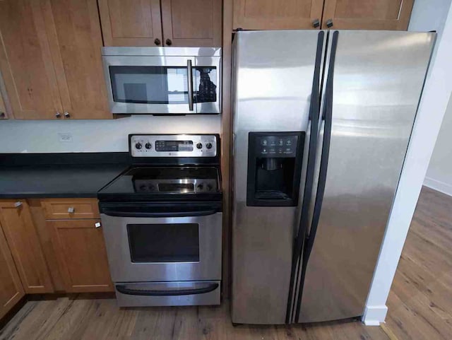 kitchen with stainless steel appliances and wood-type flooring