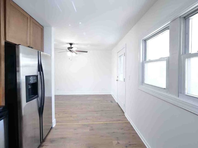 kitchen featuring ceiling fan, plenty of natural light, hardwood / wood-style floors, and stainless steel refrigerator with ice dispenser