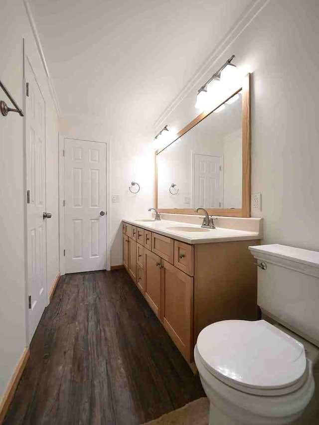 bathroom with hardwood / wood-style flooring, vanity, toilet, and crown molding