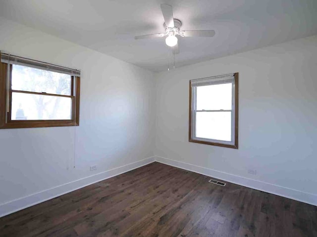 unfurnished room with ceiling fan and dark wood-type flooring