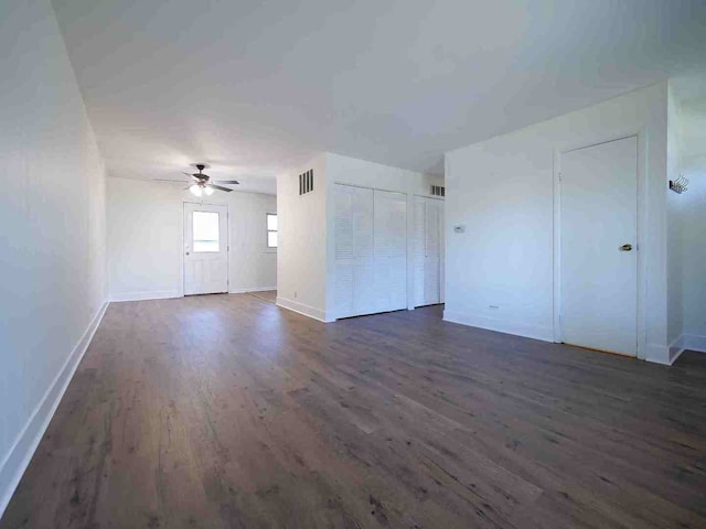 unfurnished living room with dark hardwood / wood-style floors and ceiling fan