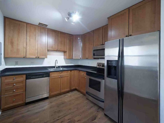 kitchen featuring appliances with stainless steel finishes, dark hardwood / wood-style flooring, and sink