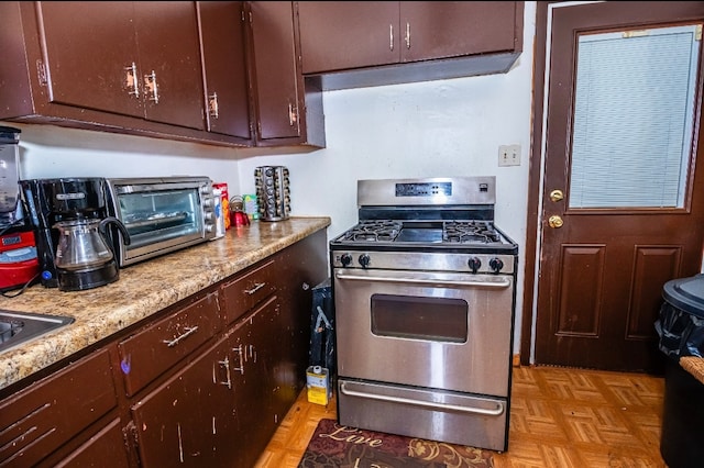 kitchen featuring light parquet flooring and stainless steel gas range oven