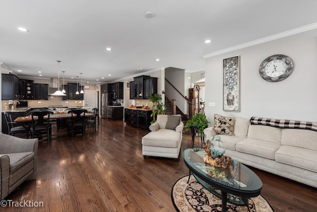 living room with dark hardwood / wood-style floors, crown molding, and sink