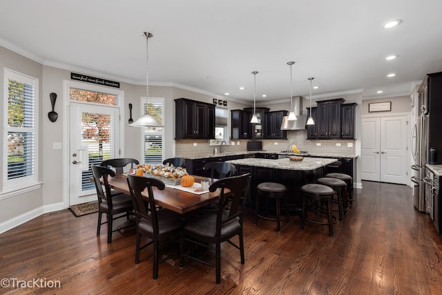 dining space featuring dark wood-type flooring, sink, and crown molding