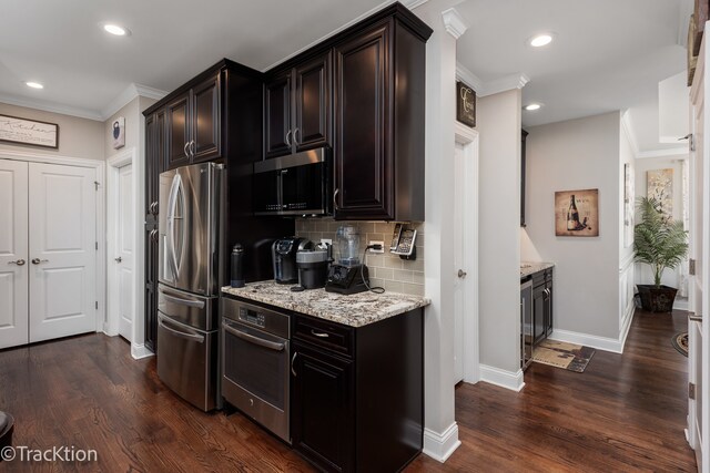 kitchen featuring tasteful backsplash, dark hardwood / wood-style floors, crown molding, light stone countertops, and appliances with stainless steel finishes