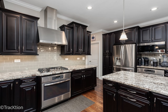 kitchen with stainless steel appliances, tasteful backsplash, decorative light fixtures, dark wood-type flooring, and wall chimney range hood