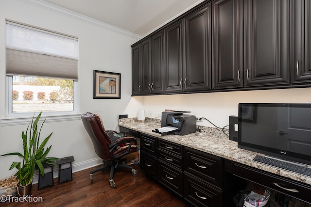 office space featuring dark wood-type flooring, built in desk, and ornamental molding