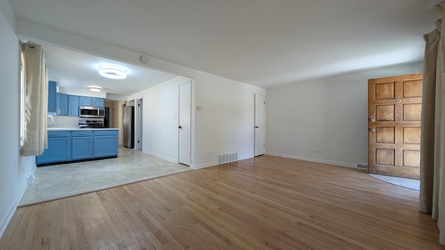 unfurnished living room with light wood-type flooring and sink