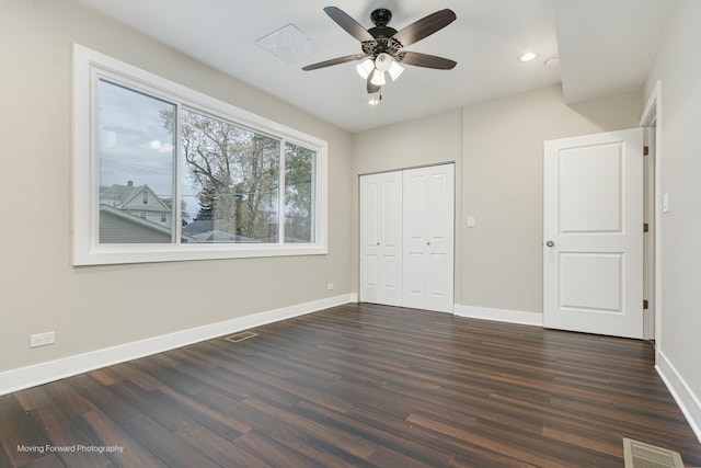 unfurnished bedroom featuring ceiling fan, dark hardwood / wood-style floors, and a closet