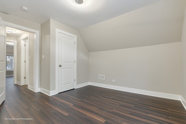 bonus room featuring dark wood-type flooring and vaulted ceiling