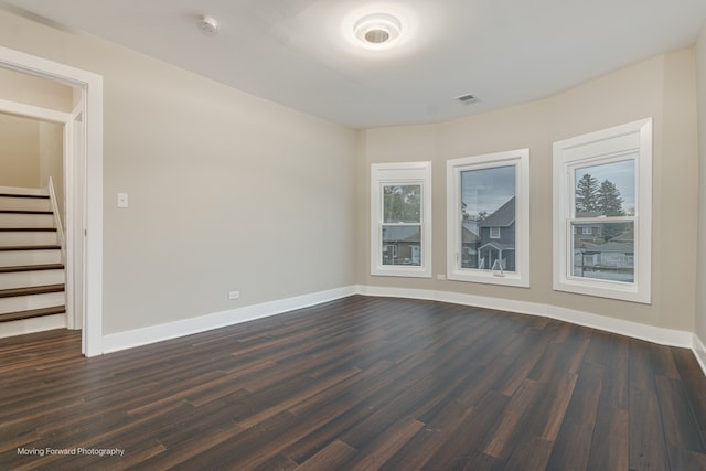 unfurnished room with dark hardwood / wood-style flooring and a wealth of natural light