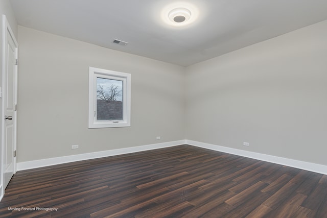 empty room with dark hardwood / wood-style flooring