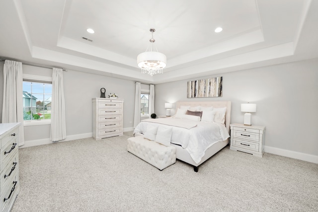 carpeted bedroom with a raised ceiling