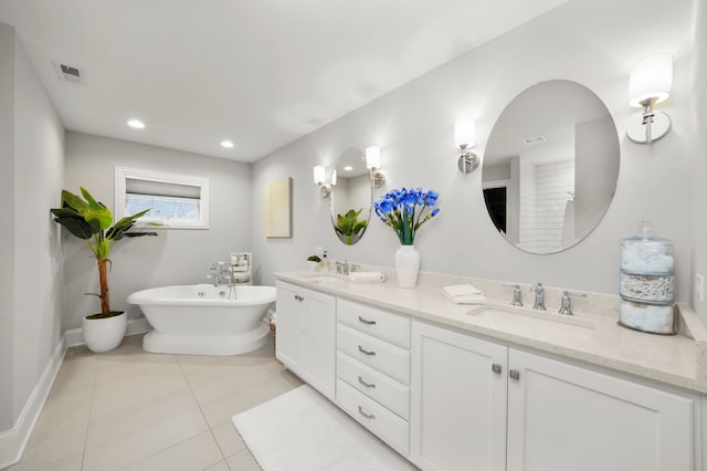 bathroom with tile patterned floors, a tub, and vanity