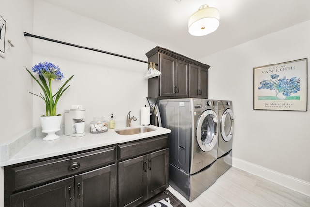 washroom featuring cabinets, sink, and washing machine and clothes dryer