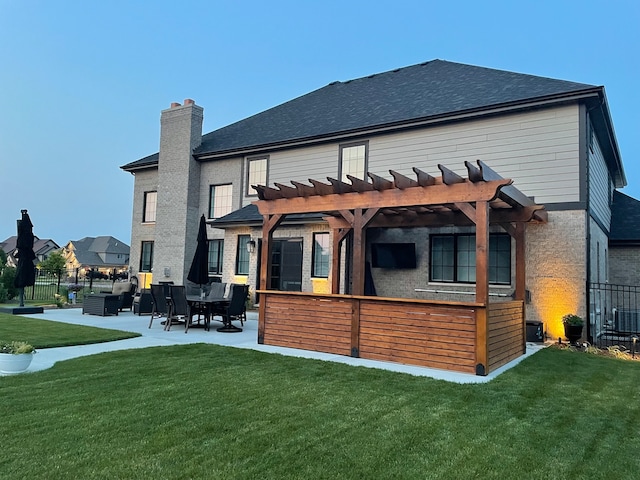 back of house with a pergola, a patio area, and a yard