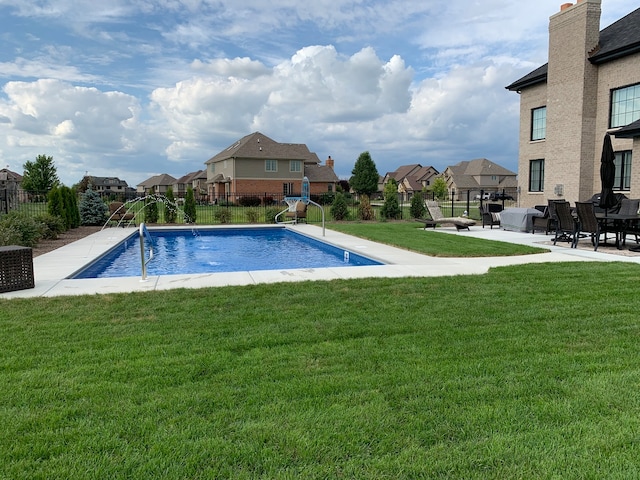 view of swimming pool featuring a yard, pool water feature, and a patio area