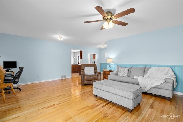 living room with light hardwood / wood-style flooring and ceiling fan