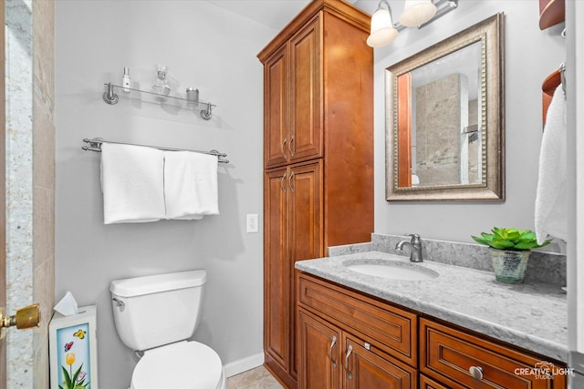 bathroom with tile patterned flooring, vanity, and toilet