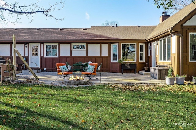 rear view of house with a lawn, a patio area, and an outdoor fire pit