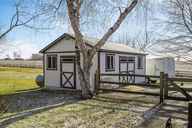 view of outbuilding with a lawn and a rural view