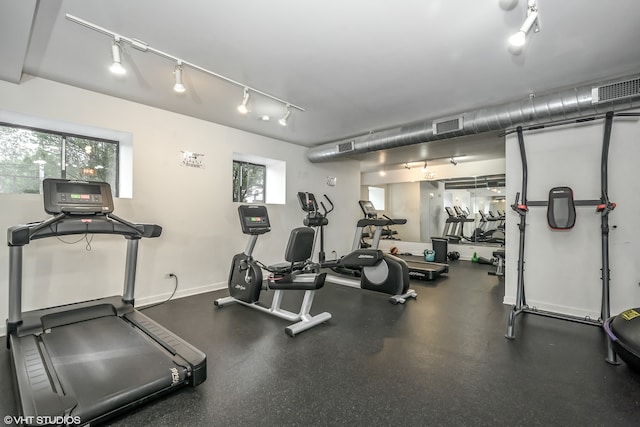 exercise room featuring rail lighting