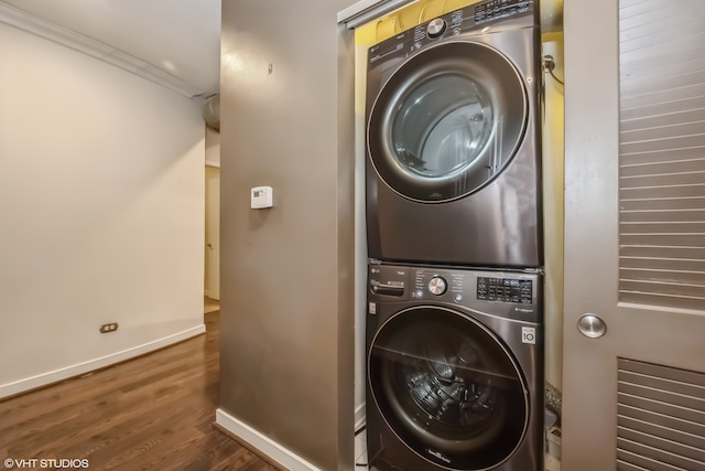 laundry area with ornamental molding, stacked washer / dryer, and dark hardwood / wood-style floors