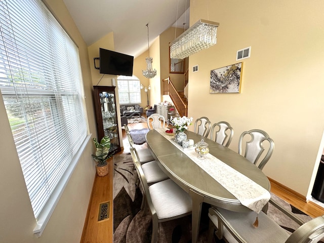 dining space with hardwood / wood-style floors and lofted ceiling