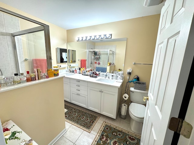 bathroom with tile patterned floors, vanity, an enclosed shower, and toilet