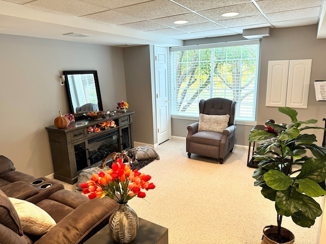 carpeted living room with a paneled ceiling