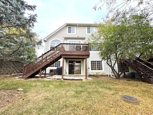 rear view of property with a lawn, a wooden deck, a patio area, and cooling unit