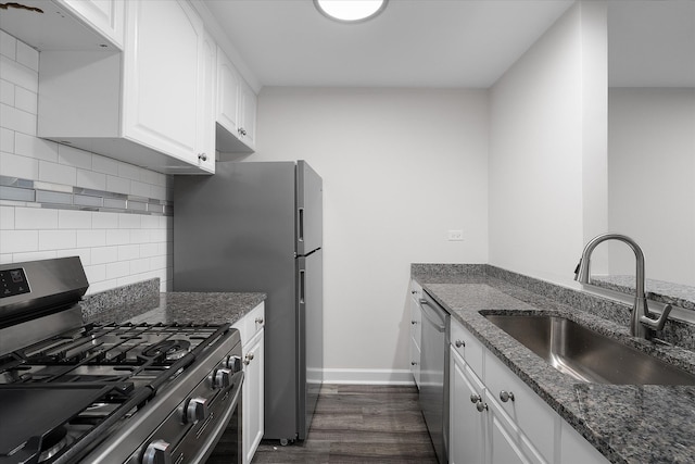 kitchen featuring stainless steel appliances, white cabinetry, sink, dark stone counters, and dark hardwood / wood-style flooring