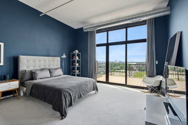 carpeted bedroom featuring a wall of windows and access to exterior