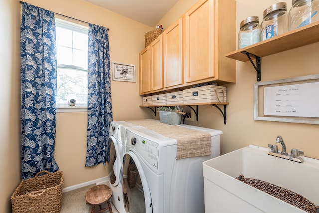 clothes washing area featuring cabinets, independent washer and dryer, and sink