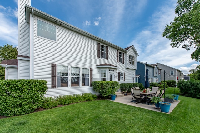 back of property featuring a patio and a lawn